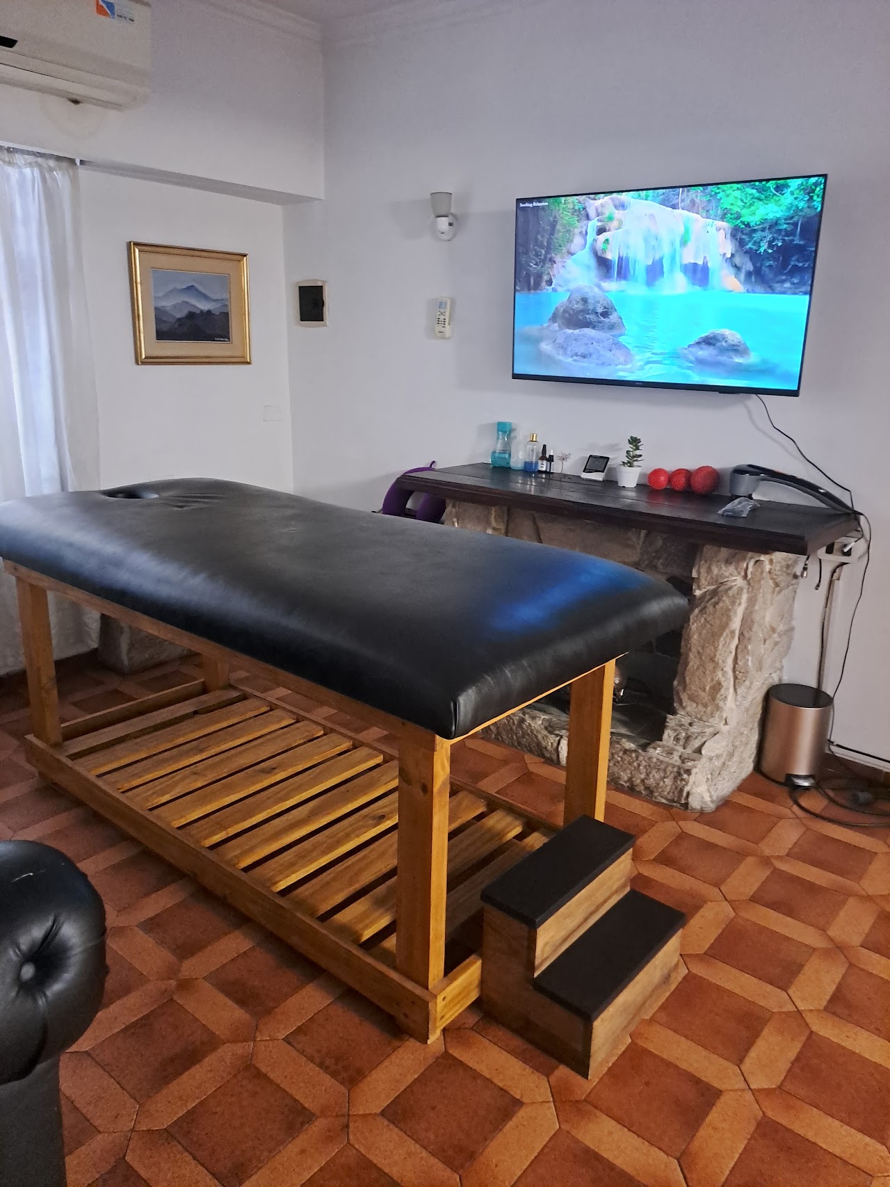 Cabina de masaje profesional en San Antonio de Padua con iluminación tenue de velas, toallas enrolladas de lino y ambientación zen